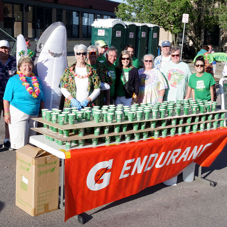 Volunteers smiling behind a table of cups of Gatorade