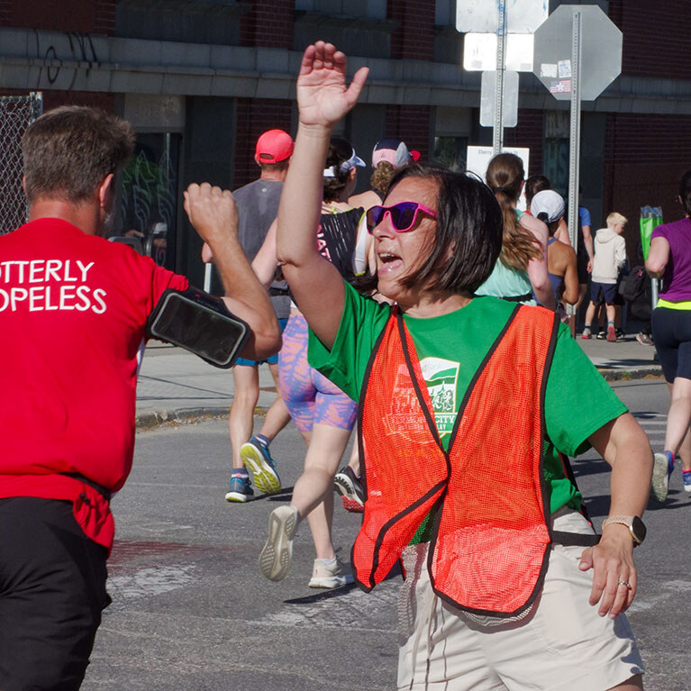 Volunteer cheering and high-fiving runners