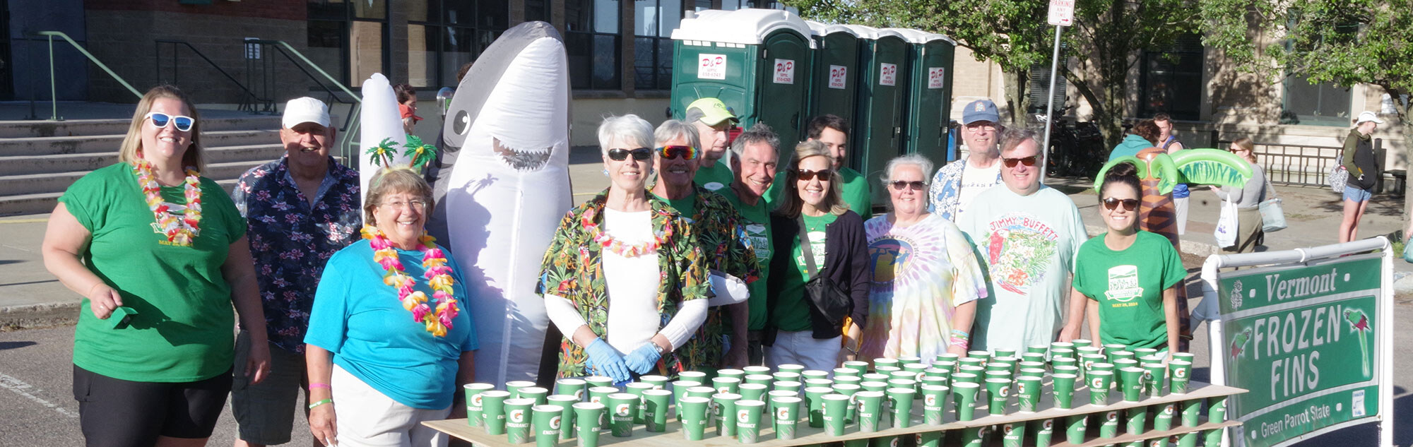 Volunteers smiling behind a table of cups of Gatorade